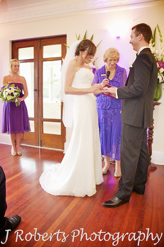 bride putting ring on groom's finger - wedding photography sydney